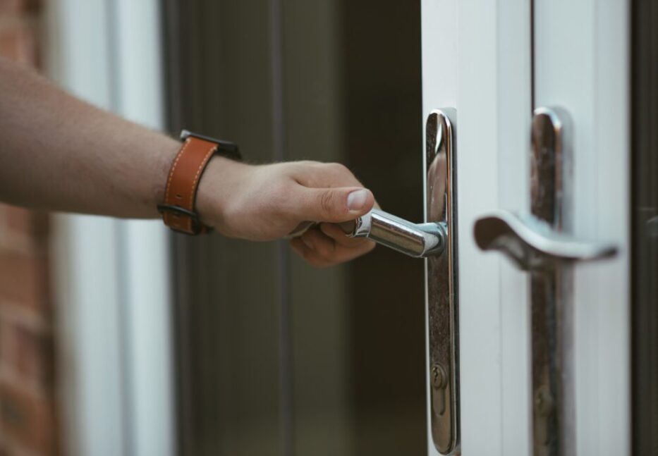Closeup shot of a person holding a door knob and opening the door Closeup shot of a person holding a door knob and opening the door